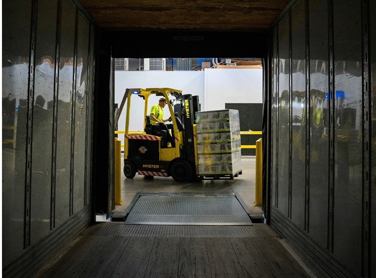 Gabelstaplerfahrer transportiert eine Palette mit Waren durch eine Laderampe
