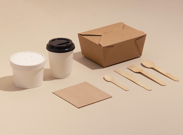 Nachhaltiges Einweg-Geschirr aus Papier und Holz: braune Foodbox, Becher, Serviette sowie Holzbesteck